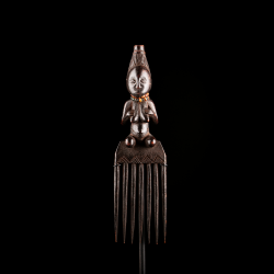 Close-up of the finely carved female figure decorating an early Luba prestige comb.