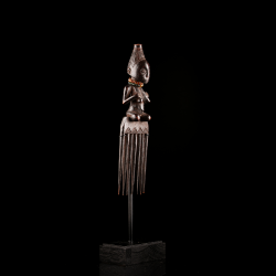 Rear view of an early Luba anthropomorphic comb revealing its refined carving and aged patina.