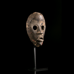 Dan Gunyege type African wooden mask displayed on a metal stand