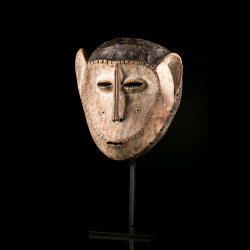 Vue trois-quarts d'un masque Lega traditionnel aux oreilles développées.