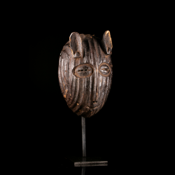 Vue de trois-quarts d'un masque traditionnel Metoko en bois avec oreilles sculptées.