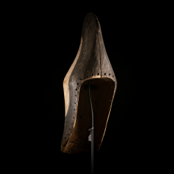 Vue arrière du masque Kifwebe Songye montrant le bois évidé et les perforations périphériques.