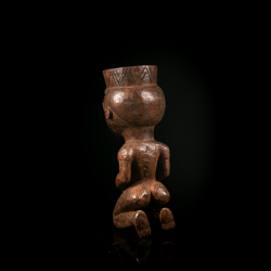 Vue arrière d'une coupe anthropomorphe Pende en bois montrant la coiffure sculptée et le récipient.