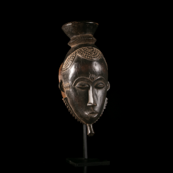 Baoulé Mblo wooden mask from Ivory Coast displayed on a custom metal stand.