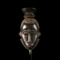 Front view of an Baoulé Mblo portrait mask with finely carved coiffure.