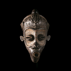 Vue de face d'un masque Bena Lulua présentant des yeux tubulaires et une bouche cylindrique.