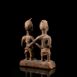 Vue arrière d'une statue de couple Kongo Lemba avec vestiges de textiles rituels.