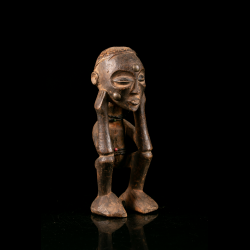 Three-quarter view of a crouching Chokwe figure with half-closed eyes.