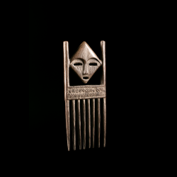Three-quarter view of a traditional Lega carved wooden comb.