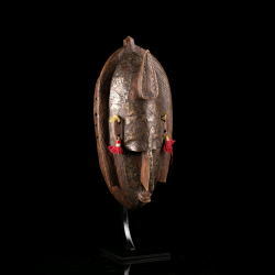 Three-quarter view of a Marka wooden mask with engraved metal covering and carved ears.
