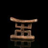 Vue opposée d’un appuie-nuque Mfinu du Congo avec assise incurvée et quatre ouvertures rectangulaires.