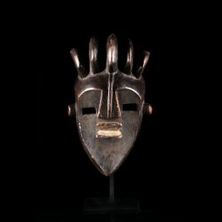 Front view of a Lwalwa Mvondo mask with projecting triangular nose, rectangular eyes and five-element headdress.