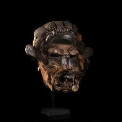 Three-quarter view of a Guéré mask from Côte d’Ivoire with cloth headdress and beard.