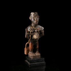 Kongo wooden Nkisi power figure with ritual charge and cowrie shell – side view