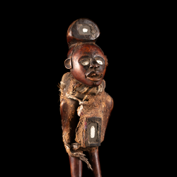Détail de la statue africaine Kongo nkisi montrant le visage aux yeux blancs et la charge rituelle fixée au torse.