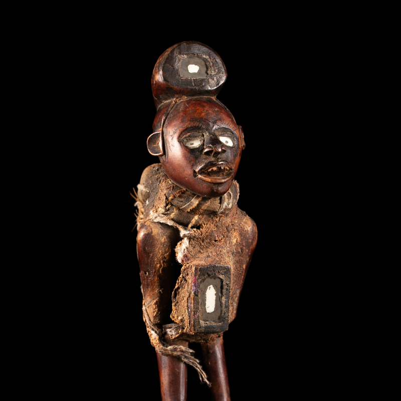 Détail de la statue africaine Kongo nkisi montrant le visage aux yeux blancs et la charge rituelle fixée au torse.