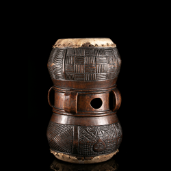Rear view of a Chokwe Mukupela drum showing carved handles, central opening and elaborate incised patterns.