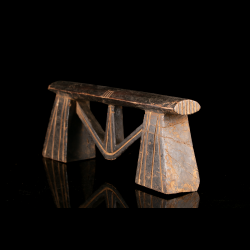 Nguni or Zulu carved wood headrest with architectural structure, side view
