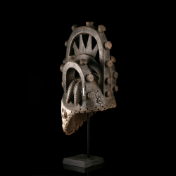 Antique Igbo Agbogho Mmuo mask with carved arches and circular projections, rear three-quarter view
